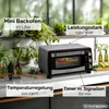 A mini oven is displayed on a kitchen counter with plants and herbs in the background. Produktbild-Vorschau