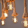 Close-up of several vintage-style Edison light bulbs hanging from ropes. Produktbild-Vorschau
