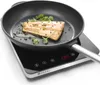 A piece of fish is being cooked in a pan on an induction cooker. Anteprima dell’immagine prodotto