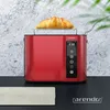 A red toaster with a croissant on top, placed on a black surface with a textured gray background. Náhled obrázku produktu
