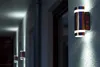 A series of outdoor wall lights illuminate a walkway at night. Produktbild-Vorschau