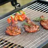 Graue Grillmatte aus Netz auf einem Grill mit kochendem Fleisch, Gemüsespießen und Rosmarinzweigen Productafbeelding-voorbeeld