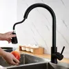 A person is washing an apple under a black kitchen faucet with a pull-out spray head. Náhľad obrázku produktu