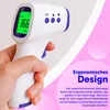 A hand holding a digital infrared thermometer against a light-colored wall with a pink graphic overlay. Produktbild-Vorschau