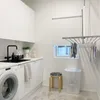 A laundry room with a washing machine, sink, cabinets, a drying rack, a stool, and a laundry basket. Podgląd zdjęcia produktu
