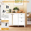A white and wood sideboard cabinet with drawers and doors, decorated with a vase of flowers, a camera, books, and fruit. The image also includes diagrams highlighting safety features. Podgląd zdjęcia produktu