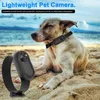 A dog wearing a camera on its collar is lying on a sandy beach with the ocean in the background. Náhled obrázku produktu
