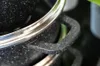 A close-up shot of the handle and rim of a black pot with a speckled finish. Náhled obrázku produktu