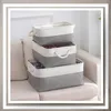 Three fabric storage baskets stacked on a couch. Anteprima dell’immagine prodotto