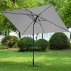 A gray rectangular patio umbrella is set up on a green lawn surrounded by bushes and trees. Produktbild-Vorschau