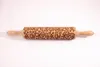 A wooden rolling pin with an engraved floral pattern is laid flat against a white background. Produktbild-Vorschau
