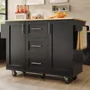 A black kitchen island with a wooden countertop is shown in a kitchen setting. It has drawers, cabinets, and a towel rack with a towel. There are also bottles and fruit on the countertop. Produktbild-Vorschau
