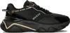 A black Guess sneaker with gold accents, shown from the side. Produktbild-Vorschau