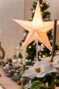 A festive table setting with a glowing star lamp, candles, and Christmas decorations. Náhled obrázku produktu
