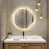 A modern bathroom vanity with a round LED mirror, sink, faucet, and decorative items. Náhled obrázku produktu