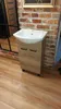 A bathroom vanity with a sink is shown in a room with brick walls and wooden flooring. Podgląd zdjęcia produktu