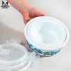 A hand is holding a set of glass food containers with lids. Produktbild-Vorschau