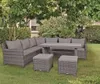 An outdoor lounge set with a sectional sofa, table, and ottomans placed on a grassy lawn under a large tree. Produktbild-Vorschau