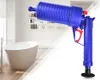 A blue drain cleaning gun is shown in front of a bathroom scene with a bathtub and shelves. Produktbild-Vorschau