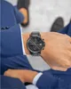 A person wearing a blue suit and a black watch. Náhled obrázku produktu