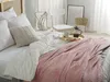 A cozy bedroom scene with a bed made up with white linens and a pink textured blanket. Náhled obrázku produktu