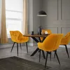 A dining set with four yellow velvet chairs around a wooden table, in a room with gray walls and a window with beige curtains. Náhled obrázku produktu