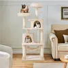 A multi-level cat tree with three cats on it, placed in a living room setting next to a sofa. Podgląd zdjęcia produktu