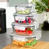 A stack of four glass food storage containers filled with various foods, including cucumbers, berries, strawberries, carrots, and peas. Produktbild-Vorschau