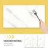 A hand holding a fork is about to touch a white marble-look panel. Below are three smaller panels and text. Produktbild-Vorschau