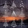 A collage of nine different hand-drawn white Christmas tree illustrations against a blurred background of trees and a sunset sky. Produktbild-Vorschau