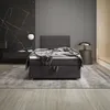 A modern bedroom with a boxspring bed, marble wall, and minimalist decor. Produktbild-Vorschau