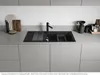 A modern kitchen sink setup with a black granite sink, faucet, and accessories. Podgląd zdjęcia produktu