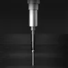 A close-up of a screwdriver bit engaging with a screw, partially inserted into a dark wooden surface. Voir les images du produit