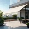 A modern patio with a retractable awning, outdoor dining set, and city skyline in the background. Náhled obrázku produktu