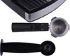 A close-up view of parts of an espresso machine, including the drip tray, portafilter, and a coffee scoop. Produktbild-Vorschau