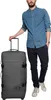 A man stands next to a large gray suitcase. Produktbild-Vorschau
