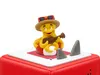 A toy octopus playing a guitar on a red cube with shark fins. Produktbild-Vorschau