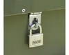 A close-up of a padlock securing a green metal storage box. Náhľad obrázku produktu