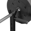 A close-up view of a barbell resting on a black weight rack, with a 10 kg weight plate visible. Náhled obrázku produktu