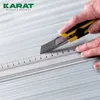 A close-up shot of hands using a utility knife and a ruler to cut a material, with a logo in the top left corner. Voir les images du produit
