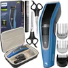 A collection of hair cutting tools including a Philips hair clipper, a storage case, scissors, and combs, laid out on a white background. Produktbild-Vorschau