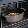 A cast iron casserole dish filled with food is placed on a rack inside an oven. Náhľad obrázku produktu