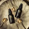 Two black bottles of Angry Beards Beard Doping serum are placed on a textured gold surface, with three spoons containing a light-colored substance. Náhľad obrázku produktu