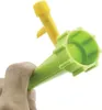 A hand holds a green plant watering device, with a yellow watering device in the background. Anteprima dell’immagine prodotto