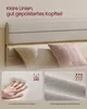 A close-up view of a bed frame's upholstered headboard with pillows, and two inset images highlighting material features. Produktbild-Vorschau