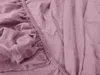 A close-up view of a pink fitted sheet, showing the elasticized edge and fabric texture. Náhled obrázku produktu