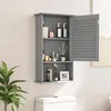 A grey bathroom wall cabinet with its door open, displaying various toiletries and decorative items on its shelves. The cabinet is mounted on a wall above a toilet tank, with a potted plant in the foreground. Podgląd zdjęcia produktu