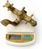 A vintage-style faucet is placed on a digital scale. Náhled obrázku produktu