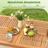 A close-up view of a wooden table with food, drinks, and flowers, set outdoors. Anteprima dell’immagine prodotto