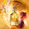 A perfume bottle with a fig and flowers in a warm, golden-toned background. Produktbild-Vorschau
